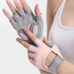 Gray and pink exercise gloves held by a person on a white background