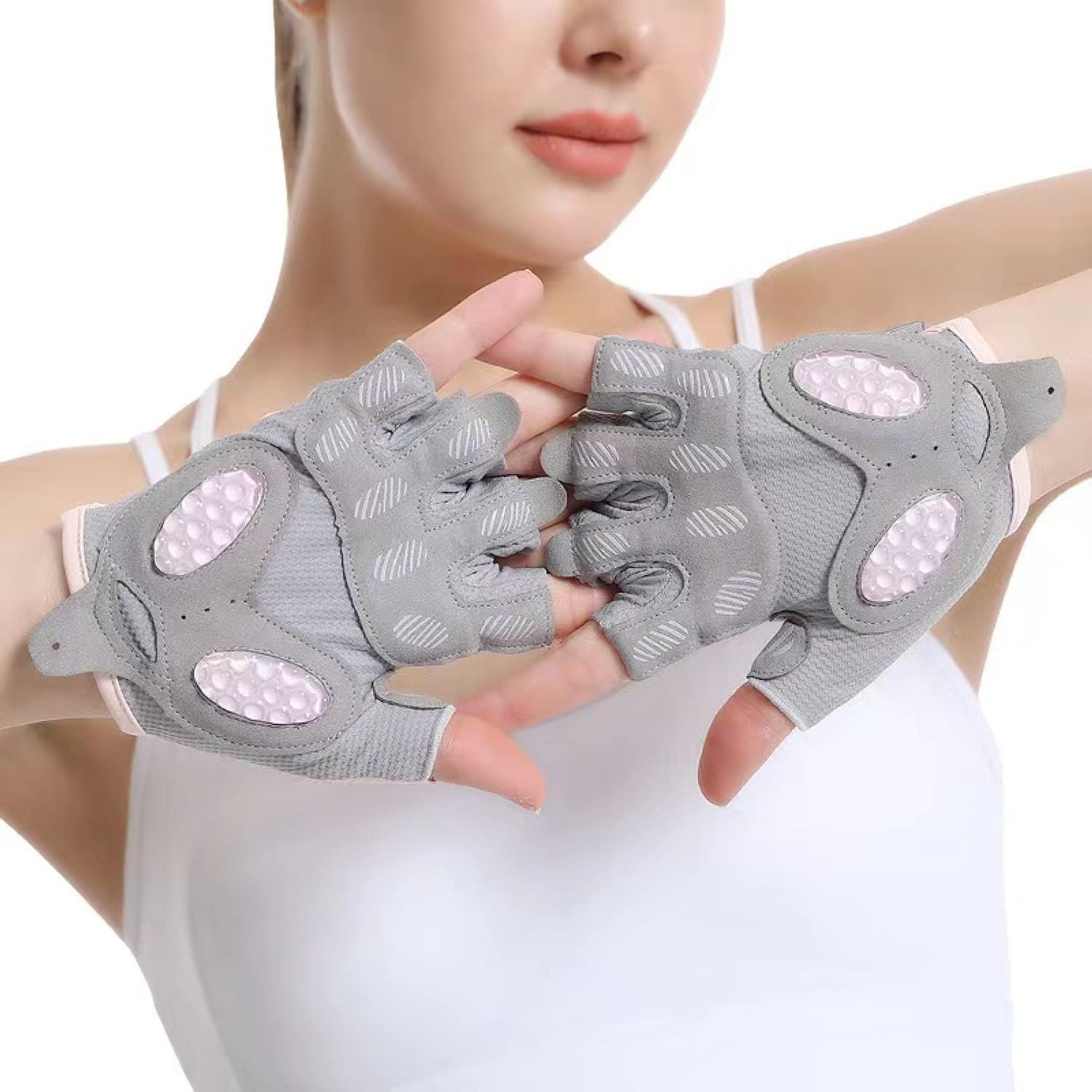 Gray gloves with pink accents held by a person against a white background